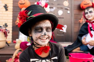 boy wiht painted face at an outdoor Halloween costume parade